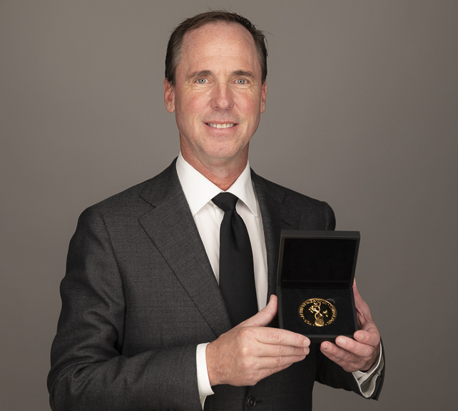 photo of Dr. Sawyer holding gold medal