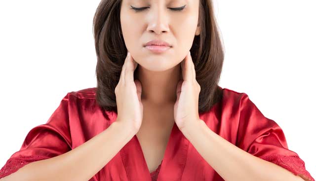 A woman is checking her throat with her hands