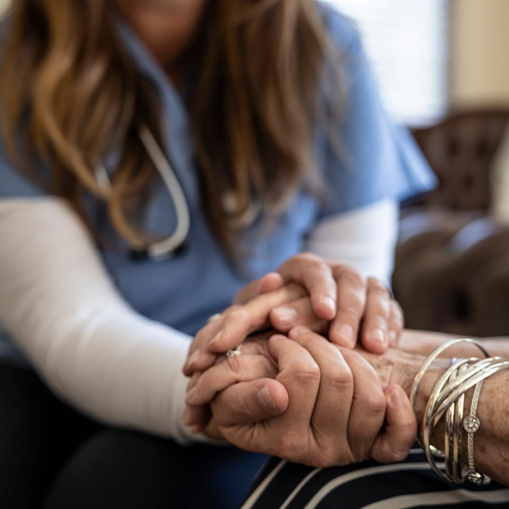 Medical Assistant supporting patient by holding their hand
