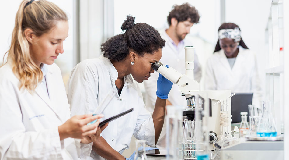 group of trainees in lab with microscopes
