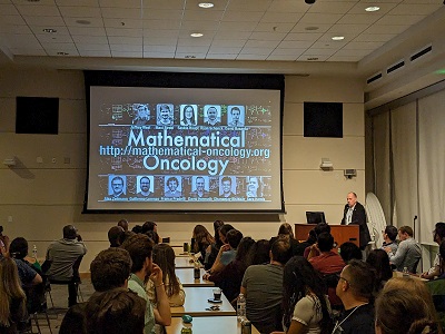 image of people gathering in a room for a presentation to start the IMO Workshop