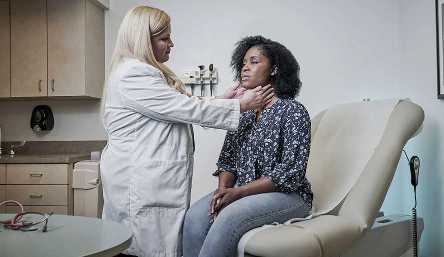 a doctor exams a woman's neck