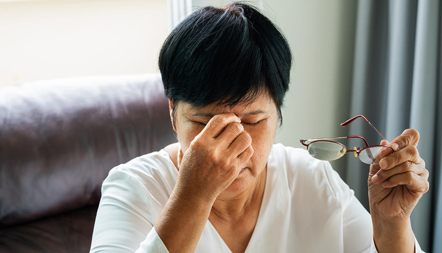 A person rubs the bridge on their nose because of a headache