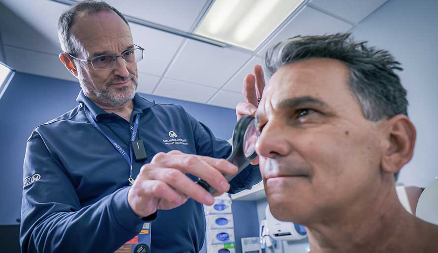 Dr. Vernon Sodak performing a skin screening