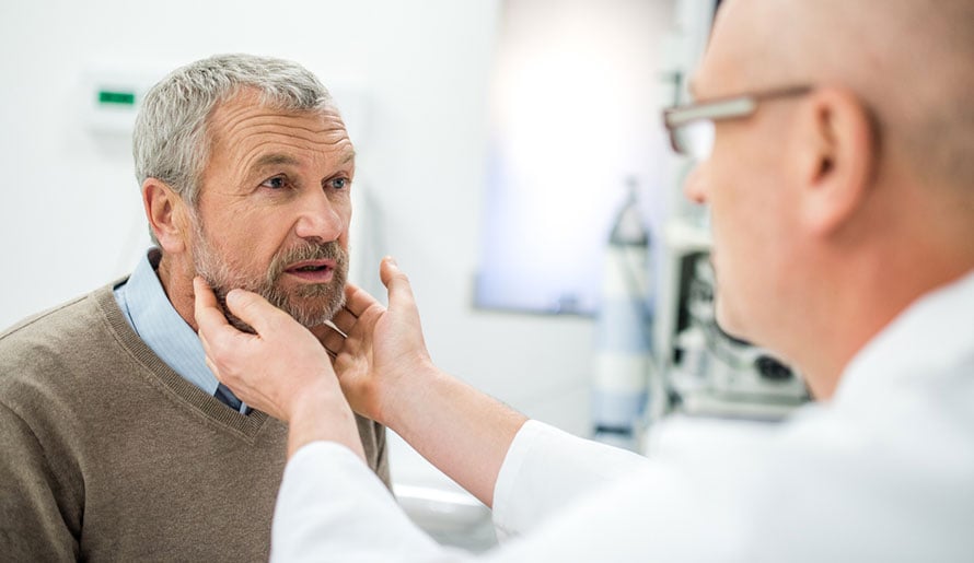 Doctor checking patient's oral cavity for verrucous squamous cell carcinoma