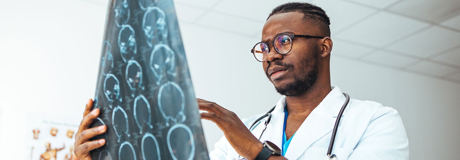 Doctor looking a brain scans to determine oligodendroglioma