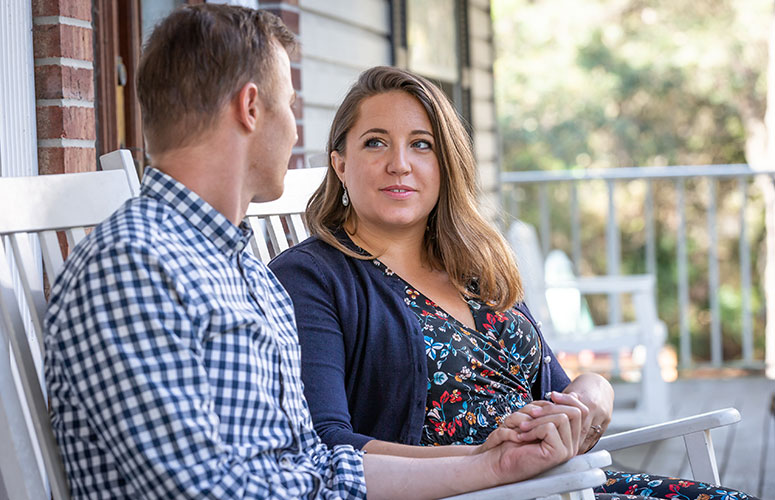 Kristen Morris sits with her husband, Caleb, on the front porch of their Tarpon Springs home.
