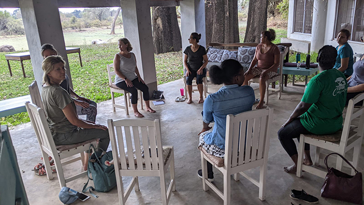 Robin Hesselink, in white, leads Chair Yoga in Zambia, Africa.