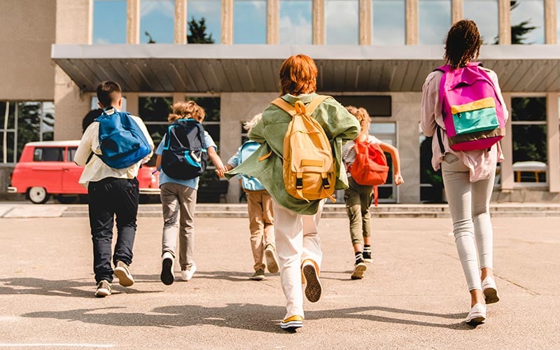 Middle school kids walking toward a school