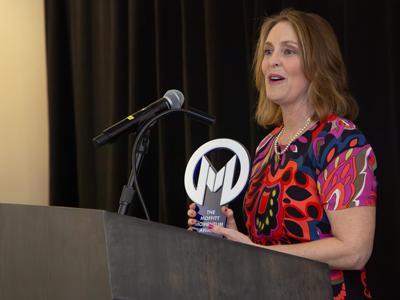 photo of U.S. Rep Kathy Castor holding Moffitt Momentum Award and speaking at a podium