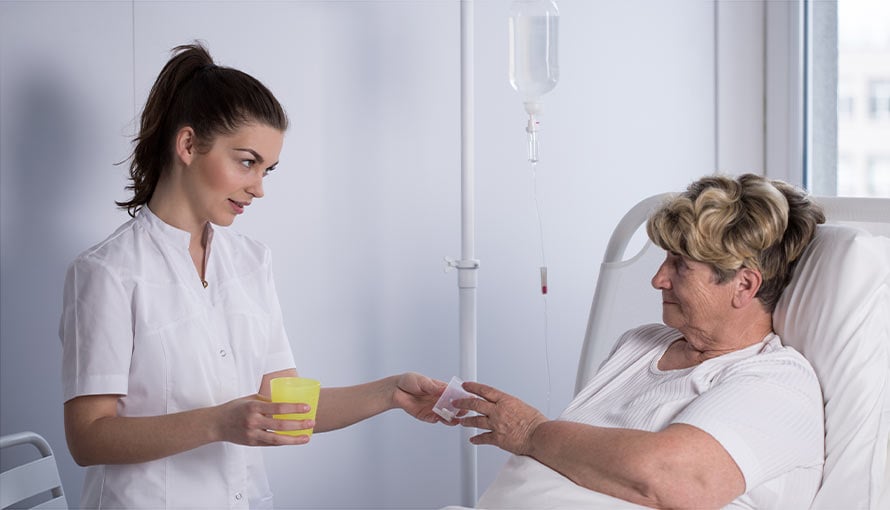 A nurse gives a woman chemotherapy pills to take.