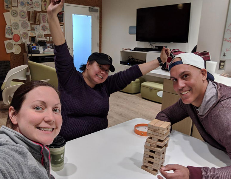 Jennifer (center) plays Jenga with Megan Wing and Joel Santos at a game night in the AYA Lounge.