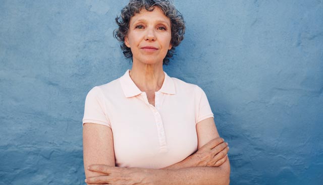 Non-Hodgkin Lymphoma patient leaning against a blue wall.