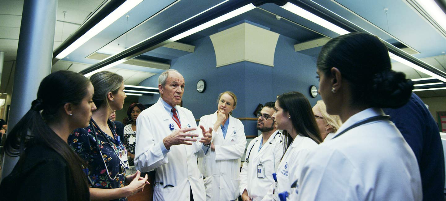 A doctor talking to interns and fellows