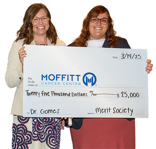 Moffitt Merit Society members holding a large check