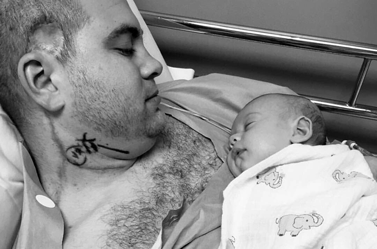 Photo of Brandon Hayes who holds his first daughter, Blakely, during an appointment at Moffitt.