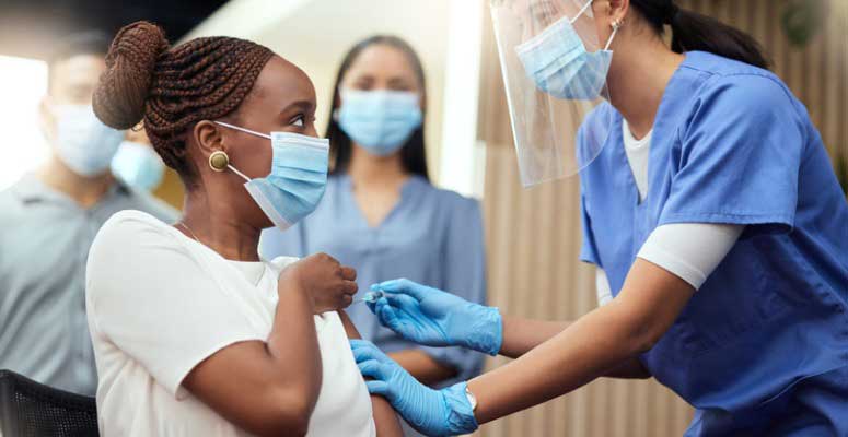 nurse administering COVID-19 vaccine to a young woman