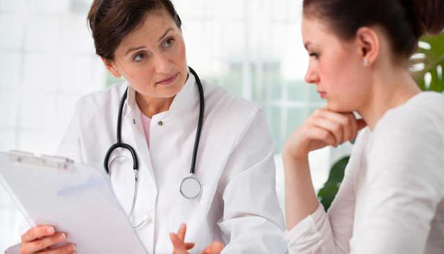 A doctor showing a woman patient paperwork about ovarian cancer treatments