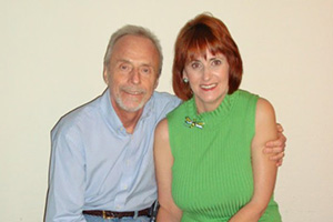 Beth and Ray Ross smile and pose for a photo while Ray has his arm wrapped around Beth