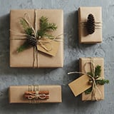 Four elegantly wrapped packages featuring twine and pine cones.