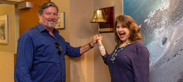 Naomi Burgess rings the bell after completing treatment alongside her husband, Brent.