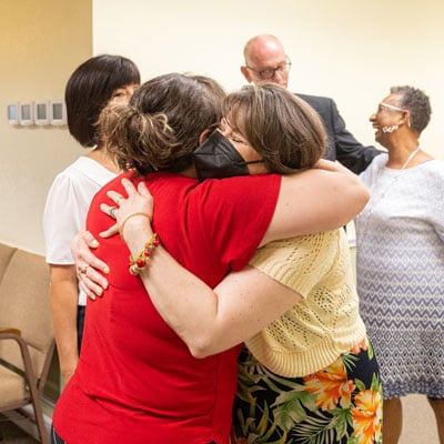 Burgess receives a warm welcome back at her first meeting since her cancer diagnosis.