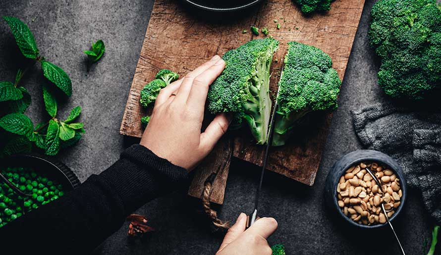 woman cutting broccoli 