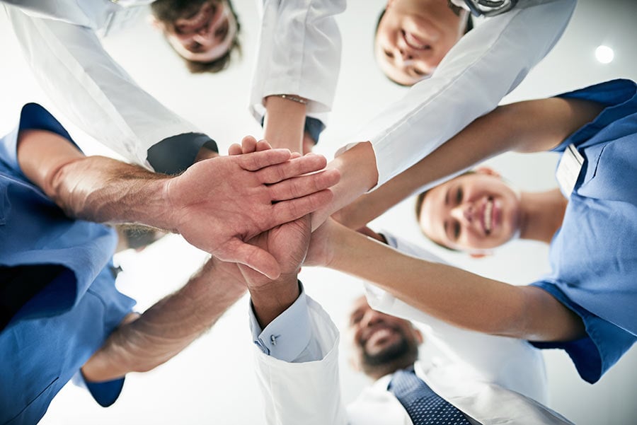 team of healthcare workers joining hands