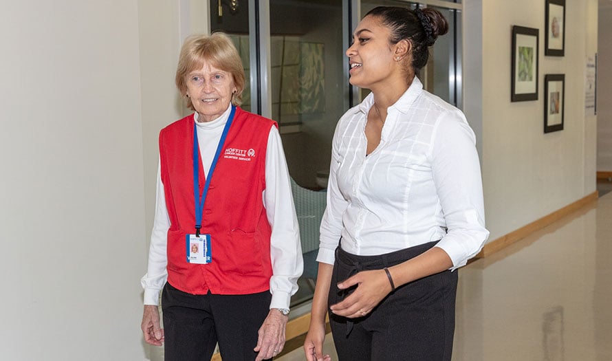 Moffitt volunteer talking with patient in hallway