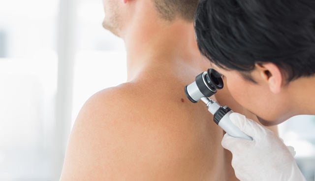 health care professional examining a man with Recurrent Basal Cell Carcinoma