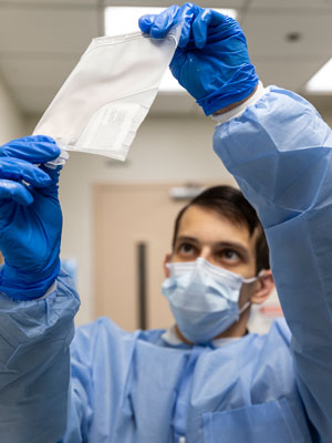 Zachary Sannasardo, a cell technologist, thaws Shannon's cells before infusion.