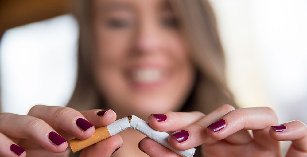 woman breaking apart cigarettes