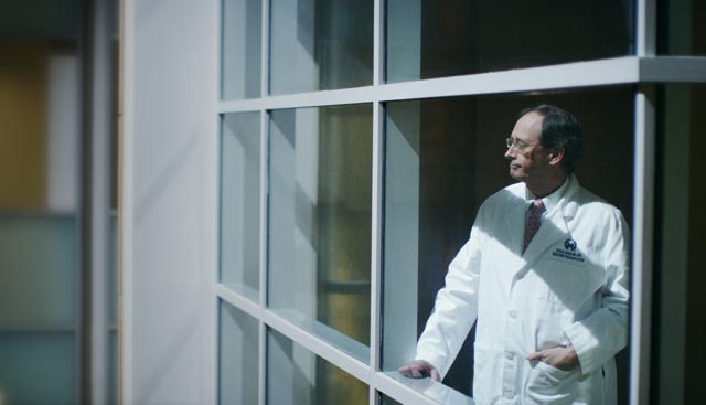 Thyroid Cancer Doctor in Tampa Florida looking over balcony of hospital in a white coat