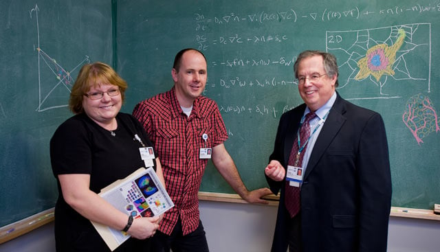 a research team stands in front of a blackboard