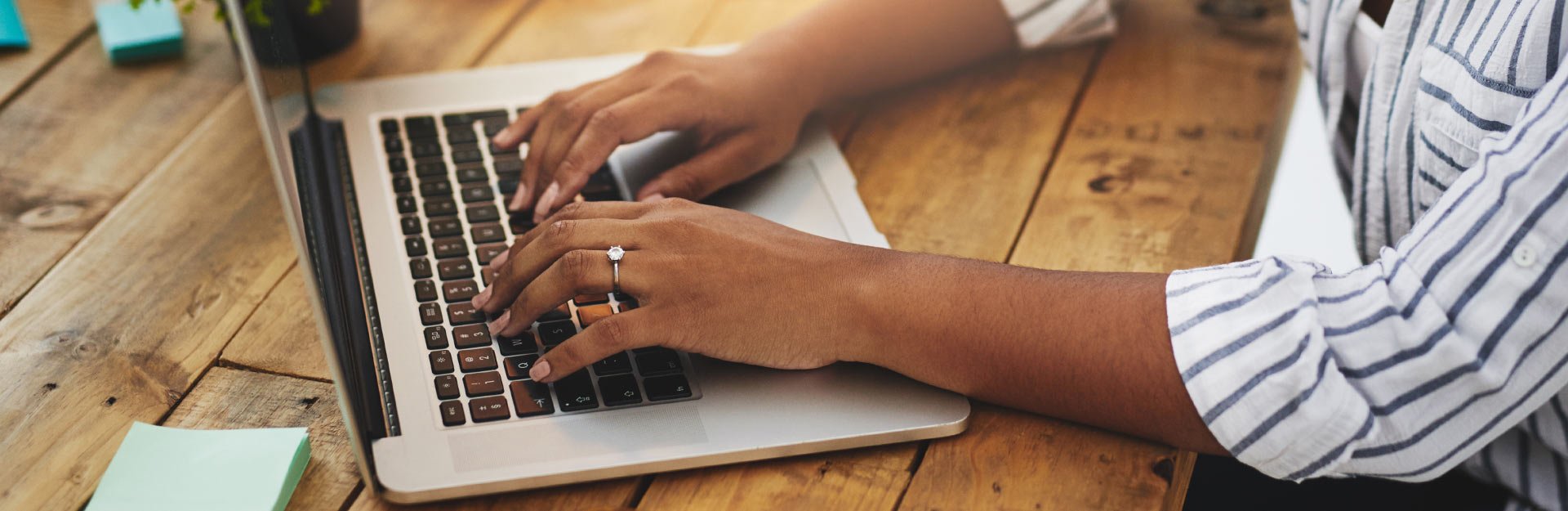 a woman types on a laptop computer