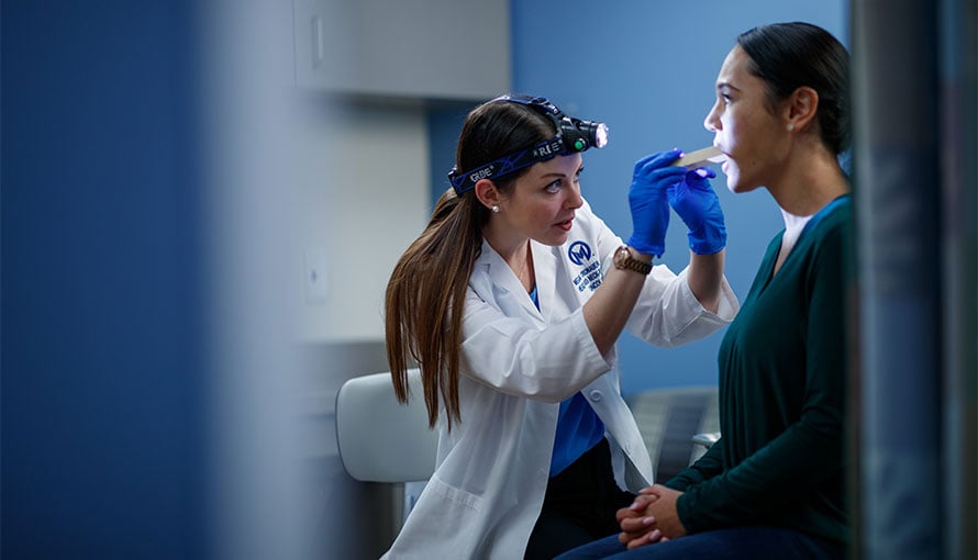 Doctor checking patient's throat