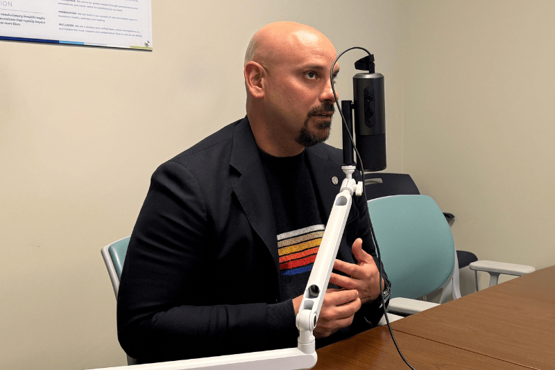 Joshua sitting at a podcast microphone