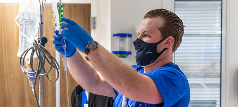 Nurse Ivan Ross hangs a bag with the TIL to be infused into a patient.