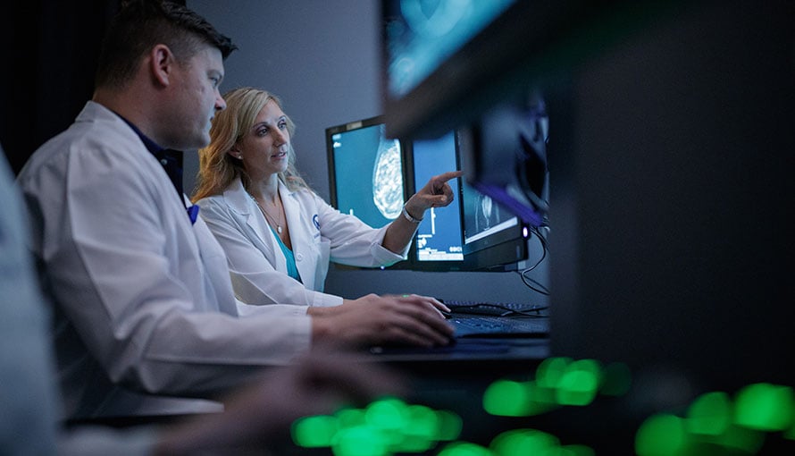 Breast cancer radiologists study a patient's scan.