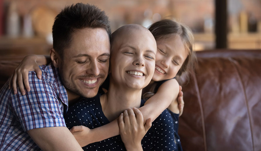 mom with cancer hugs husband and child