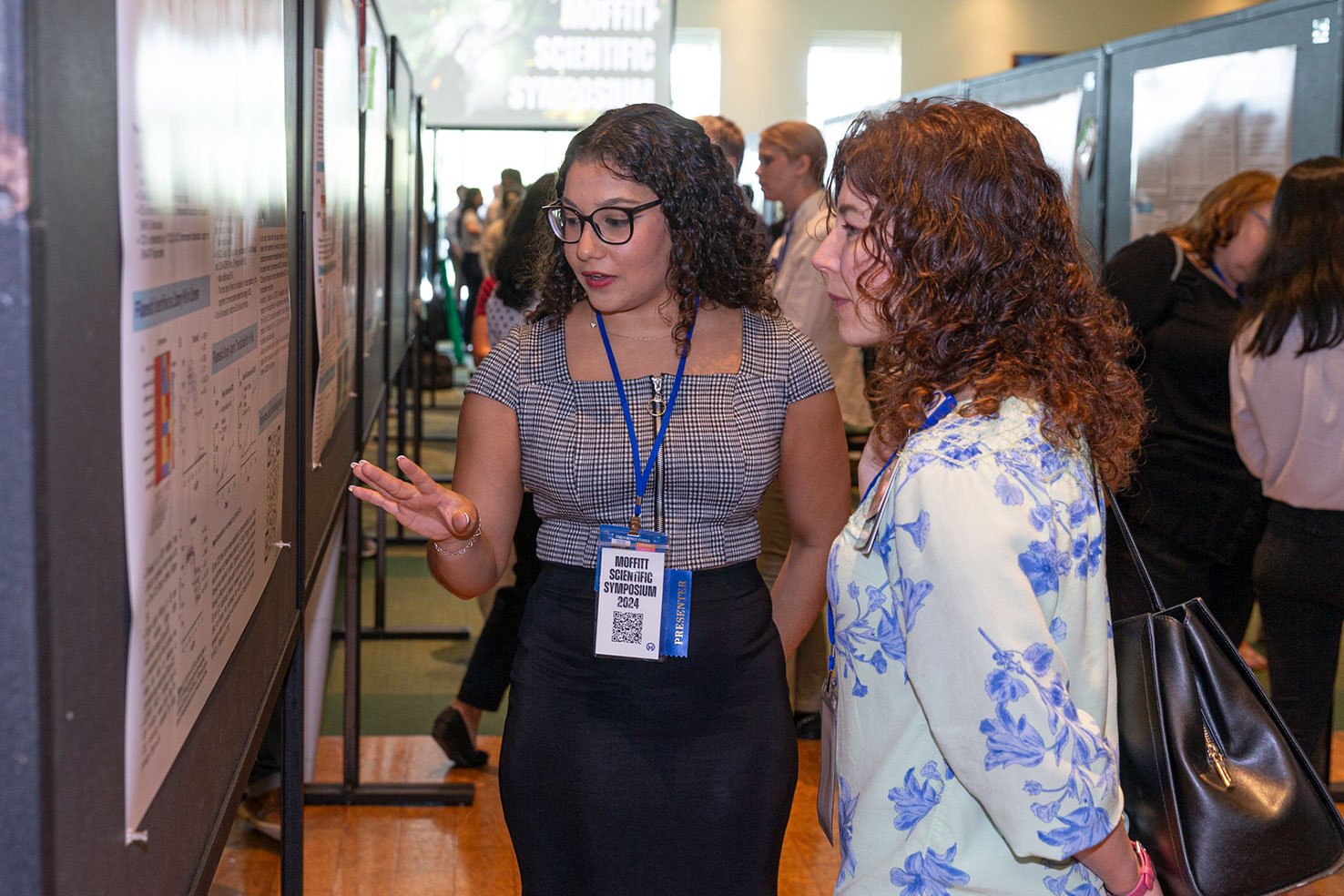 Dr. Karen Mann reads an intern's poster