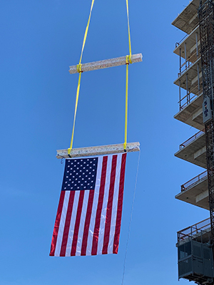 image of two beams being lifted with flag hanging below