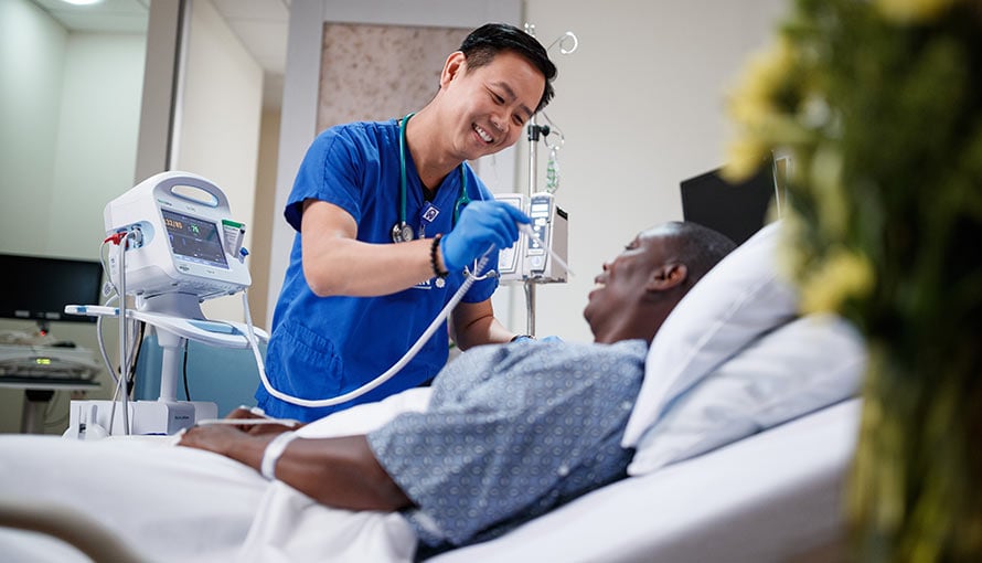 A critical care nurse is taking a patient's temperature.