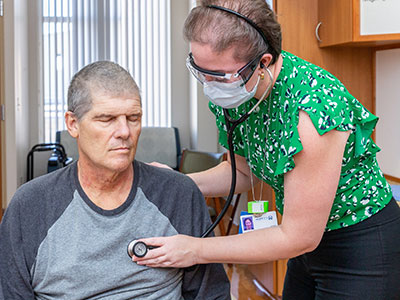 Dr. Aliyah Baluch examines patient Rene Gauthier on the Bone Marrow Transplant Floor.