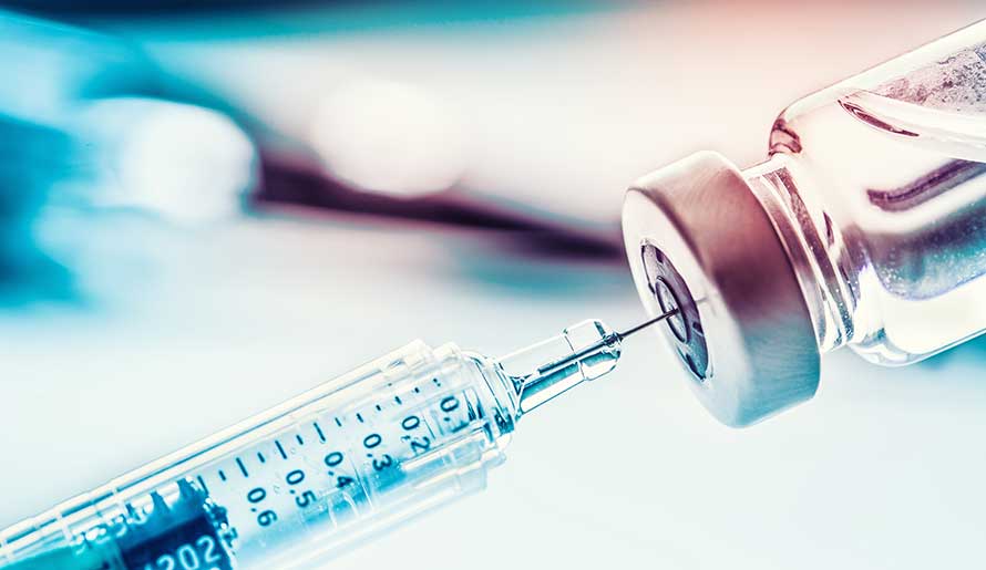 a syringe is being filled from a vaccine vial