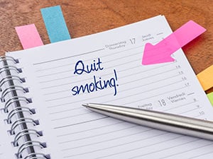 A desk calendar with a note that says quit smoking