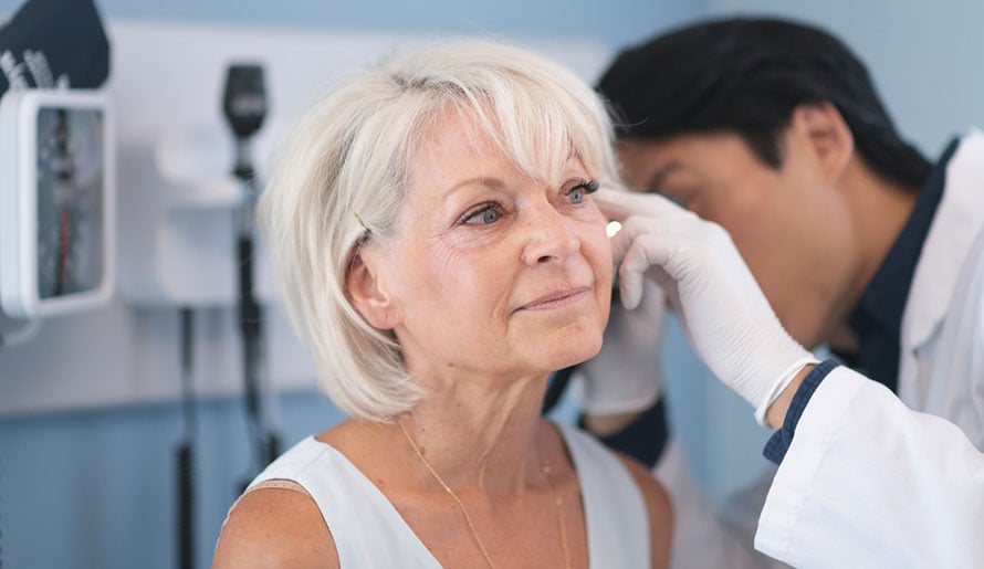 Doctor checks patient's face for intraepidermal squamous cell carcinoma