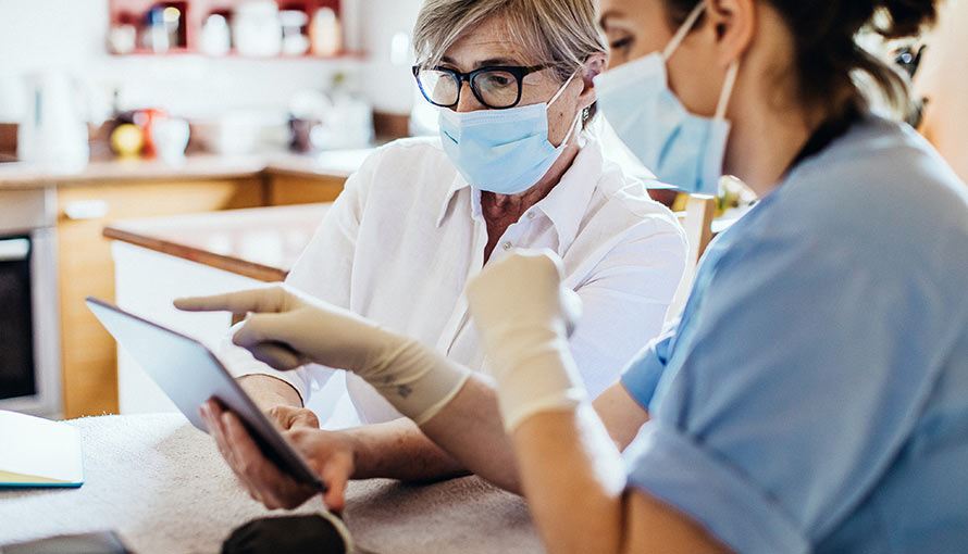 A doctor shows a patient treatment information on a tablet computer