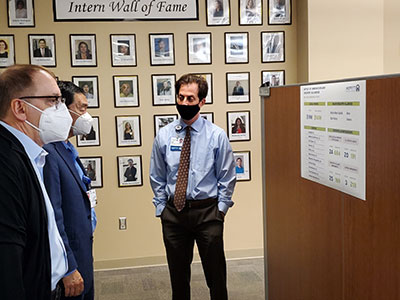Senior Director of Innovation Jarrett Rieger gives Hwu a tour of the Moffitt Innovation Office as part of Hwu's rounding.