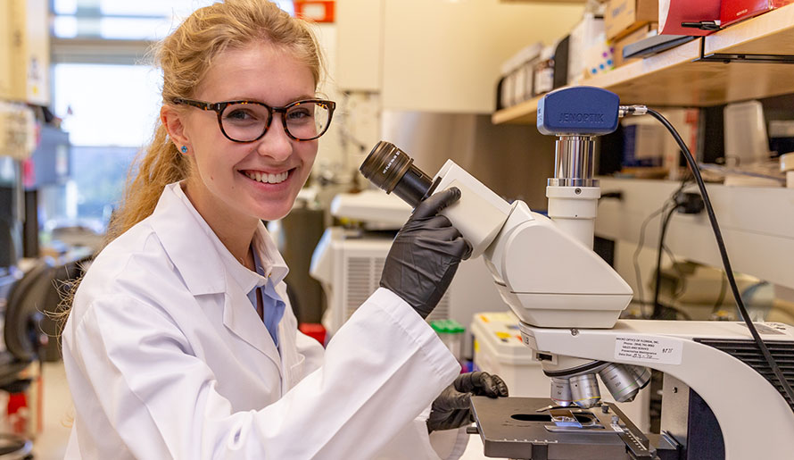 GLOW participant in front of microscope
